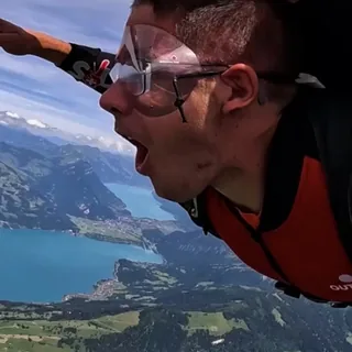 William skydiving over a lake.